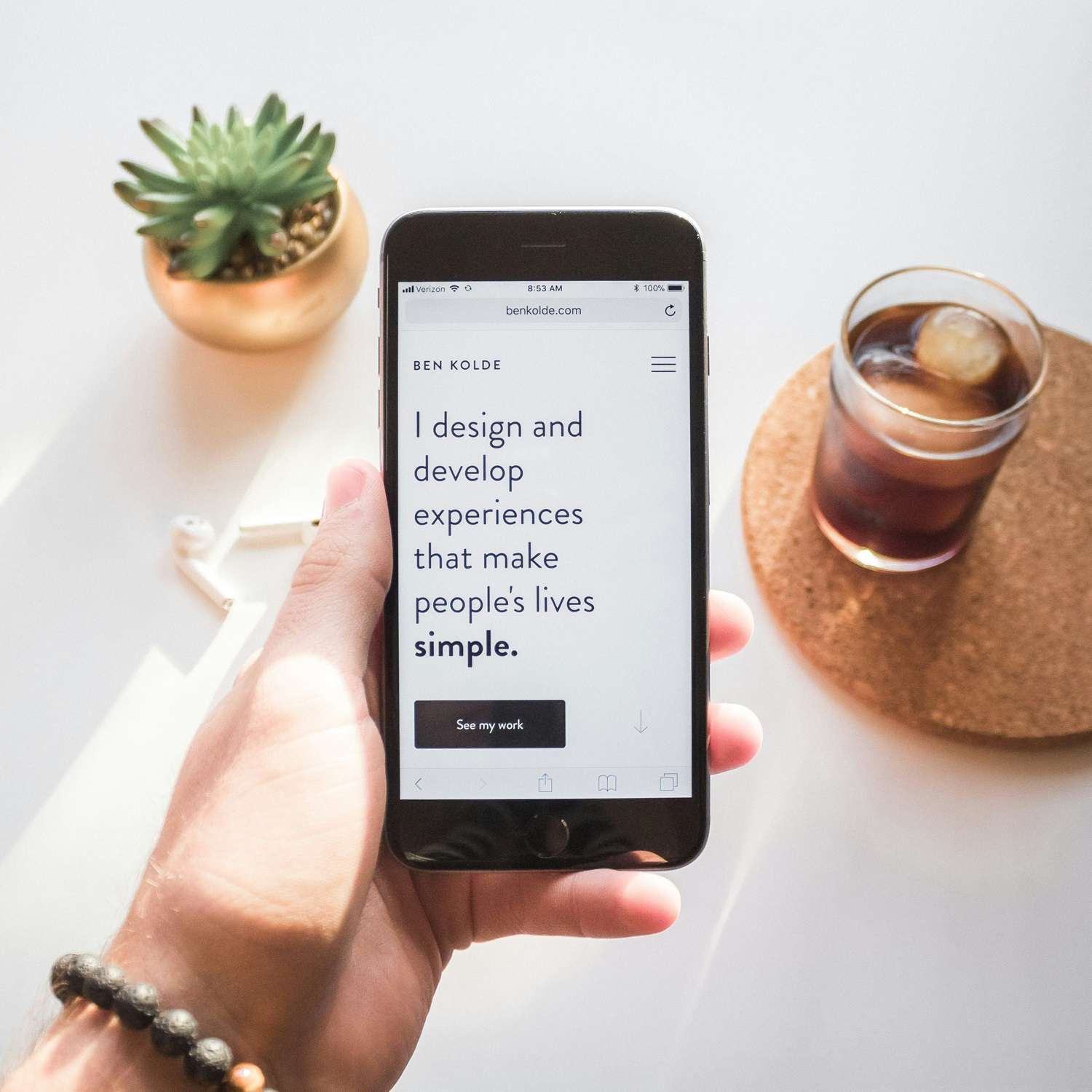 Hand hält ein Smartphone mit dem Spruch: I design and develop experiences that make people's lives simple. für Responsive Design im Aargau